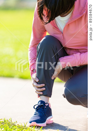 運動中に痛めたふくらはぎを押さえるミドル女性 89384670