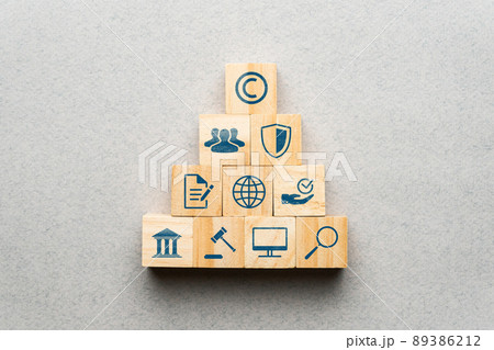 The concept of copyright and intellectual property. Protection, law and regulation icons on wooden blocks. 89386212
