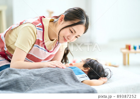 保育園時を寝かしつける女性保育士 89387252