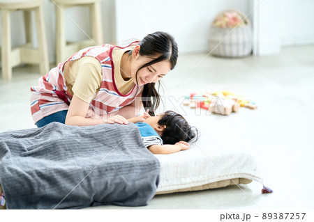 保育園時を寝かしつける女性保育士 89387257