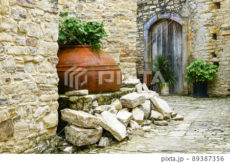 courtyard in a mountain village in Cyprus with huge old terracotta amphora pot used as a flower pot courtyard in a mountain village in Cyprus with huge old terracotta amphora pot used as a flower pot 89387356