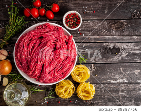 Mince beef, ground meat with ingredients for cooking on dark blue 89387756