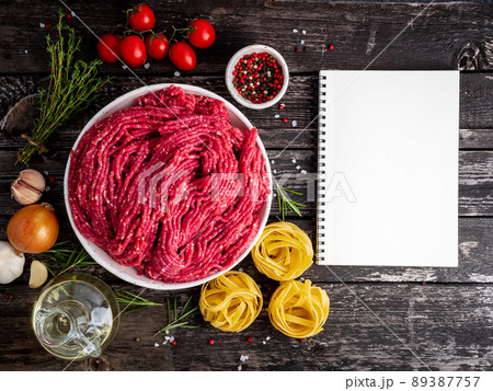 Mince beef, ground meat with ingredients for cooking on dark blue Mince beef, ground meat with ingredients for cooking on dark blue 89387757