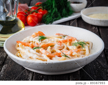 italian pasta spaghetti with shrimps, bechamel sauce and chopped dill 89387993