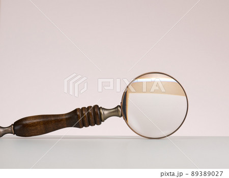 wooden magnifier on a white background. The concept of uncertainty and the search for solutions, doubts 89389027