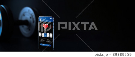 Gym app. Smartphone screen with sport gym or fitness health mobile application on black dumbbell background. App for training indoors. Gym app. Smartphone screen with sport gym or fitness health mobile application on black dumbbell background. App for training indoors. 89389559