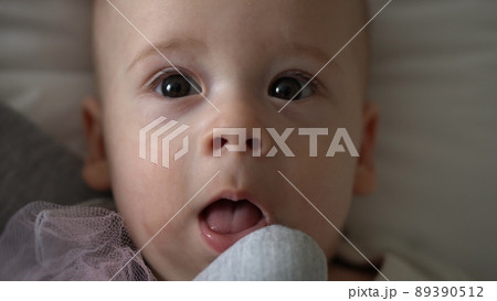 Close-up Happy playful kid 6 month old. Newborn boy looking at camera after bath shower on white soft bed. baby child waking time before bedtime with Toy. Childhood, motherhood, family, infant concept 89390512