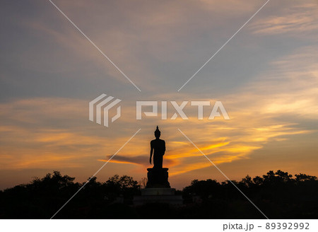 Silhouette technique under golden twilight evening sky with Walking Buddha statue in Thailand 89392992
