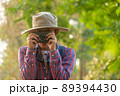 Asian man holding a camera with both hands.man wearing a hat taking pictures,copy space 89394430