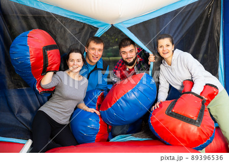 Happy men and women on inflatable arena 89396536