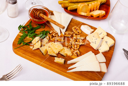 Varieties of cheese sliced and served with honey Varieties of cheese sliced and served with honey 89396688