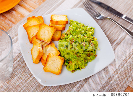 Portion of fresh guacamole with rusks served on table 89396704