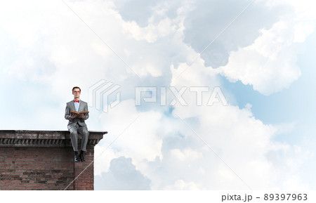 Young businessman or student studying the science on building roof Young businessman or student studying the science on building roof 89397963