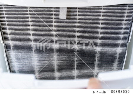 Asian woman changing the dirty air purifier filter after using for a long time in the dirty air environment. Using air purifier clean the air for better atmosphere in a house. 89398656