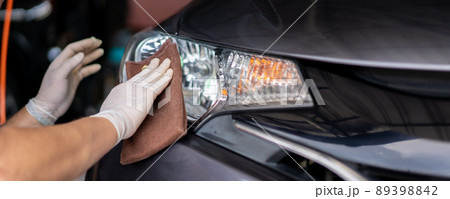 Asian workman wiping a car with high quality microfiber cloth in garage. Professional car care workshop. 89398842