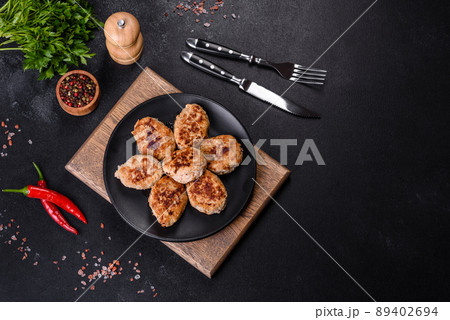 Delicious fresh fried minced meat patties on a dark concrete background Delicious fresh fried minced meat patties on a dark concrete background 89402694
