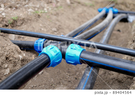 Connection of plastic sewer pipes closeup. Irrigation system for vegetable garden concept 89404564