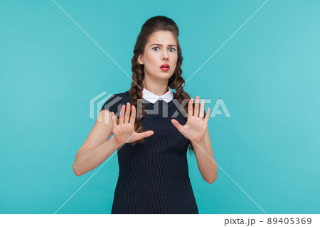 Fear or nightmare concept. Shocked beautiful woman looking at camera. Indoor, studio shot on blue background Fear or nightmare concept. Shocked beautiful woman looking at camera. Indoor, studio shot on blue background 89405369