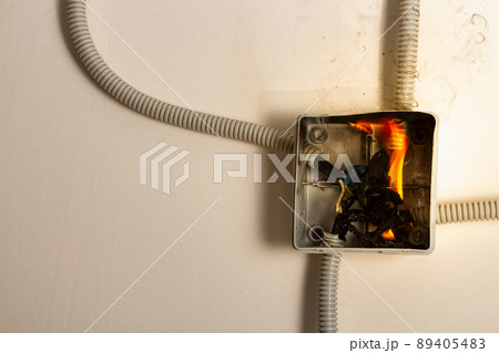Electrical wires on fire. The concept of electrical short circuit and fire at home 89405483