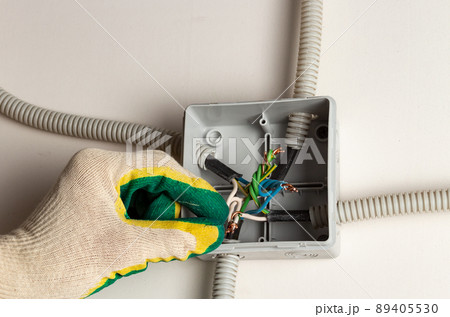 gloved hand mounts wire insulation. the concept of repairing electrical equipment at home 89405530