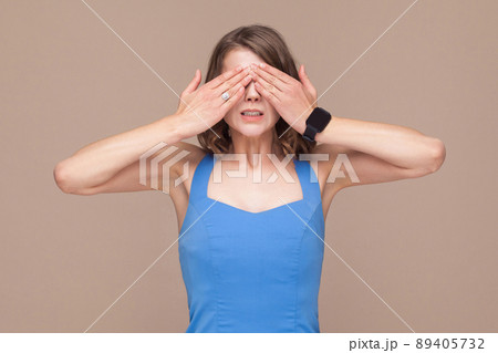 Not interesting. Woman in blue dress closed eyes her hands. Indoor shot 89405732