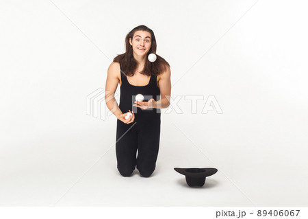 Beggar, ask. Juggler looking at camera and juggling balls. Indoor shot 89406067