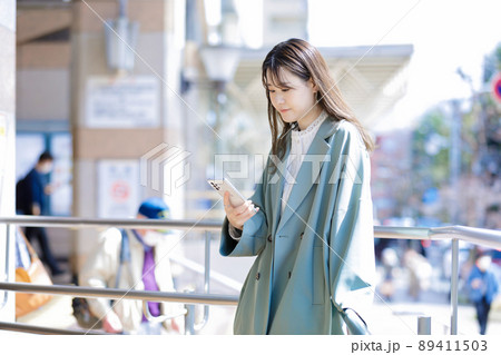 街でスマホを使う若い女性 89411503