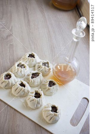 The process of making home-made dumplings. Raw homemade dumplings on a wooden board. Molding dumplings. 89414517