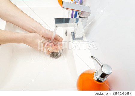 Washing of hands with soap under running water in white sink. close - up. antivirus protection wash your hands. Washing of hands with soap under running water in white sink. close - up. antivirus protection wash your hands. 89414697
