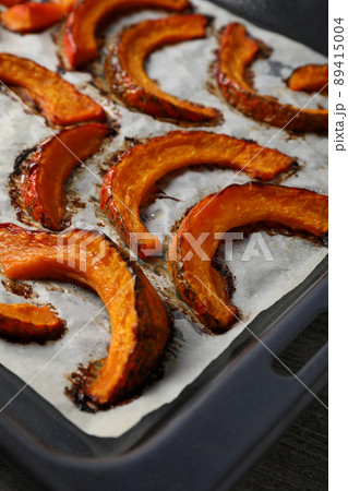 Baking tray with baked pumpkin on gray textured background 89415004
