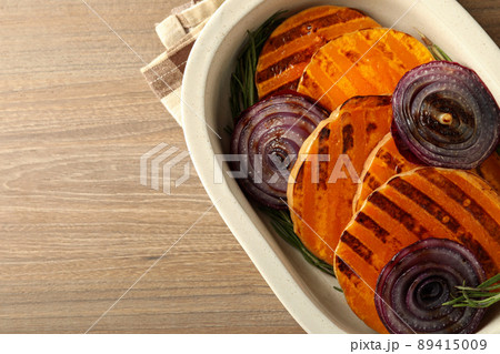 Baking tray with baked pumpkin on wooden background 89415009