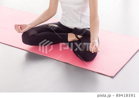 Anonymous woman sitting in lotus posture, doing yoga. Studio shot Anonymous woman sitting in lotus posture, doing yoga. Studio shot 89418391