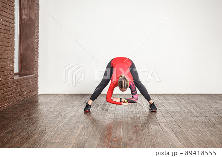 Sexy blonde woman standing in uttanasana pose. Studio shot Sexy blonde woman standing in uttanasana pose. Studio shot 89418555