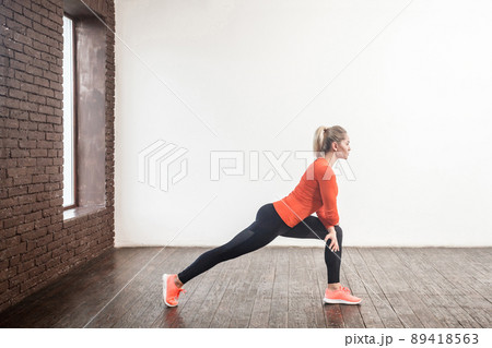 Weight loss concept. Profile woman doing gymnastics indoor. Studio shot Weight loss concept. Profile woman doing gymnastics indoor. Studio shot 89418563