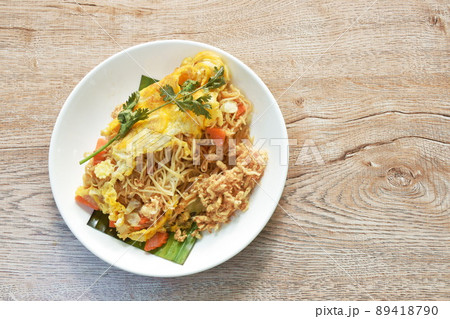 fried rice noodles with vegetable wrapped egg topping dry shredded pork on plate 89418790
