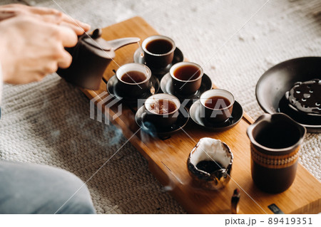 Close-up of pouring tea for a tea ceremony in a large company Close-up of pouring tea for a tea ceremony in a large company 89419351