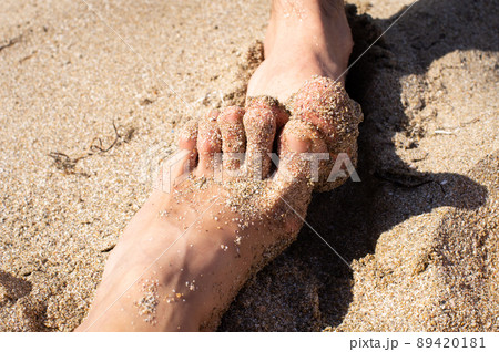 The concept of a couple on vacation, women's feet and men's feet on the beach by the sea. Front view. 89420181