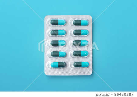 Capsule medicine in pack, antibiotic pills on blue background, top view 89420287