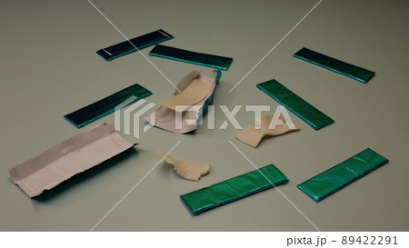 Mint sticks of gum are strewn across the table. Sweet chewing gum for cleaning the mouth from food. 89422291