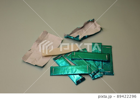 Mint sticks of gum are strewn across the table. Sweet chewing gum for cleaning the mouth from food. Mint sticks of gum are strewn across the table. Sweet chewing gum for cleaning the mouth from food. 89422296