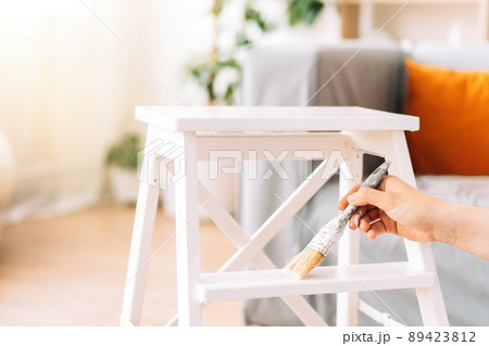 Painting wooden chair white colour with brush Painting wooden chair white colour with brush 89423812