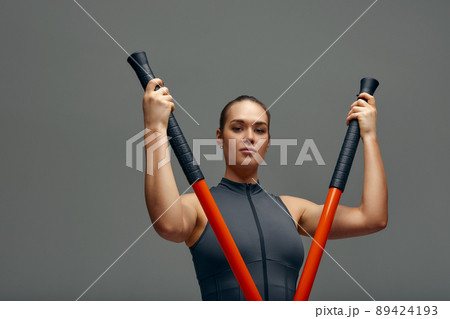 beautiful girl in sports uniform is training kung fu in the studio, fighter athlete, practicing martial arts with a stick 89424193