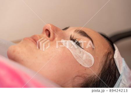 Eyelash extension procedure. Woman eye with long eyelashes. lashes, close up, macro, selective focus. 89424213