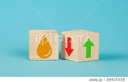 Wooden cube change UP arrow and Down arrow and oil symbol on blue background. Oil with arrow up 89425556