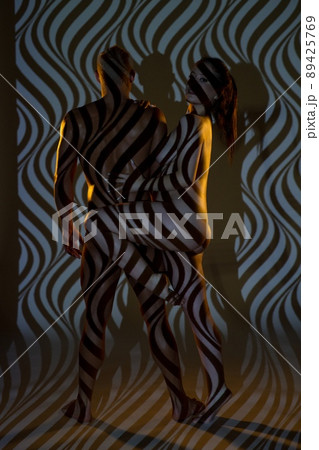 Muscular man and Nude female models under projector shadows Muscular man and Nude female models under projector shadows 89425769