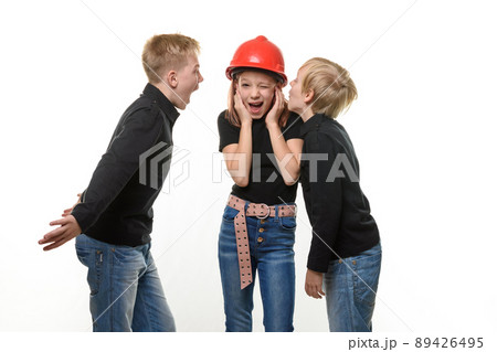 Two boys are shouting at a girl, the girl is standing in a helmet in a hard hat and plugged her ears, isolated on a white background 89426495