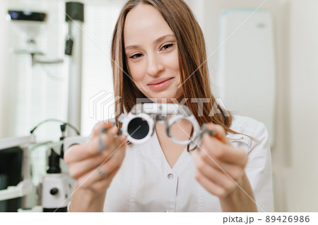 ophthalmologist with trial frame for selection of glasses. selective focus ophthalmologist with trial frame for selection of glasses. selective focus 89426986
