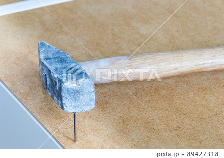 Nails embedded in the furniture with hammer. Nails embedded in the furniture with hammer. 89427318