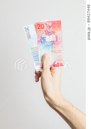 20 EUR and 20 CHF banknotes held in hand. 20 EUR and 20 CHF banknotes held in hand. 89427446