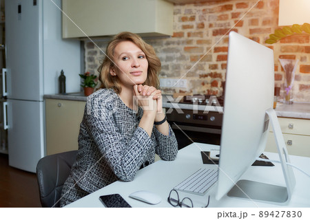 A woman working on a desktop computer with her employees at a video conference. A woman working on a desktop computer with her employees at a video conference. 89427830